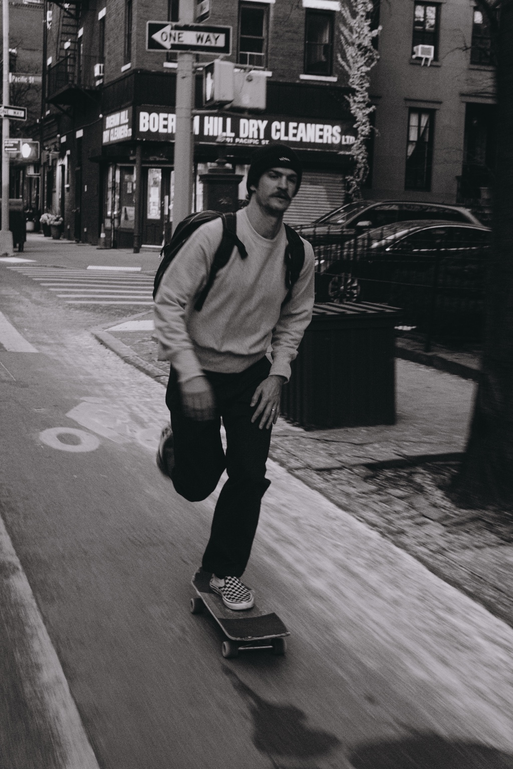 Skateboarder riding toward the camera on a city street